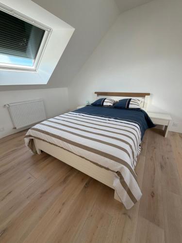 a large bed in a bedroom with a wooden floor at Villa Danni in Quiberon