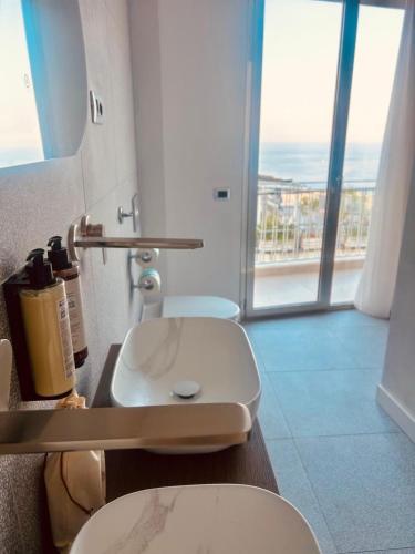 a bathroom with a toilet and a sink with a view at Amaurusa Boutique Hotel in Taormina