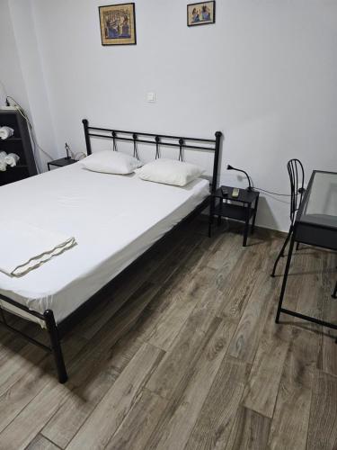 a bed in a room with a wooden floor at Aspa's house in Athens