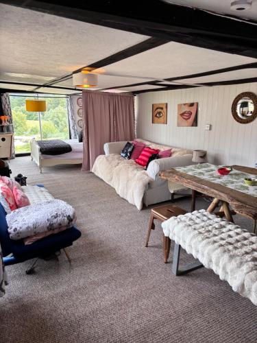 a living room with couches and a table at Farmstay cabin firepit & activities in Hertford