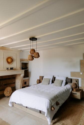 a bedroom with a large bed and a table at Le Domaine des peupliers in Saint-Germain-du-Seudre