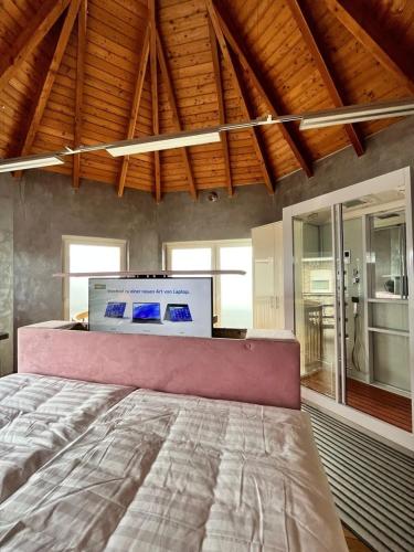 a bedroom with a large bed in a room with windows at Auszeit am Dankernsee in Altharen