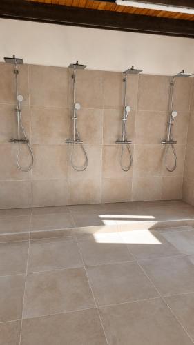 ein Badezimmer mit vier Schläuchen an einer Wand in der Unterkunft Ausee Camping in Blindenmarkt
