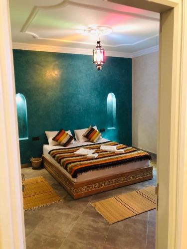 a bedroom with a large bed with a blue wall at Zakar Apartments & Terrace 2 in Mirleft