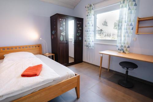 a bedroom with a bed and a desk and a window at Haus Freija in Sehestedt
