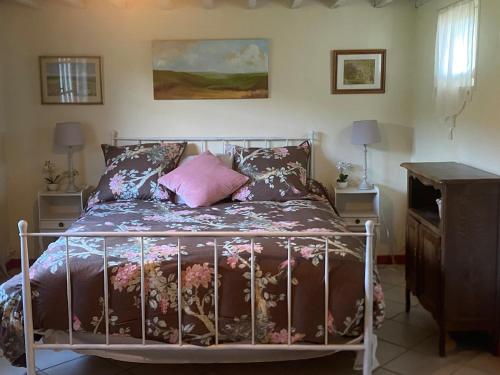 a bedroom with a bed with a metal frame and pillows at Maison du Verger in Brosville