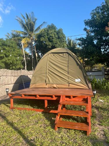 a tent sitting on a picnic table in the grass at Ayira Campsite in Vilankulo Airport