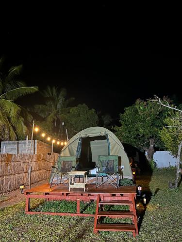 a tent with two chairs and a table in front of it at Ayira Campsite in Vilankulo Airport