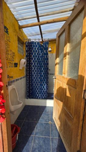 a bathroom with a shower and a toilet and a door at Moon Garden House in Pisac