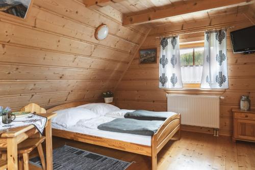 a bedroom with a bed in a log cabin at Willa Rohacze in Kościelisko