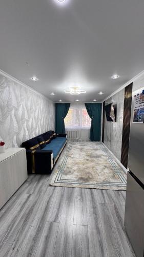 a room with a bed and a rug on the floor at Квартира посуточно in Balqash