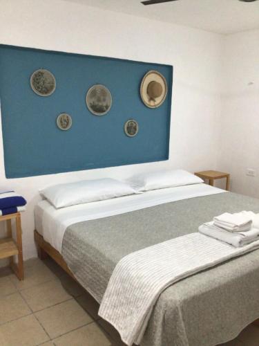a bedroom with a bed with a blue head board at Paz y Mar in Chelem
