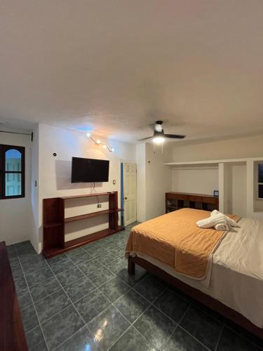 a bedroom with a bed and a flat screen tv at Marvin Suites in Holbox Island