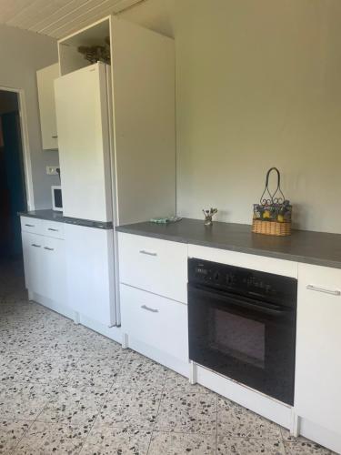 a kitchen with white cabinets and a black oven at Belle vue étoilée in Saint-Ouen