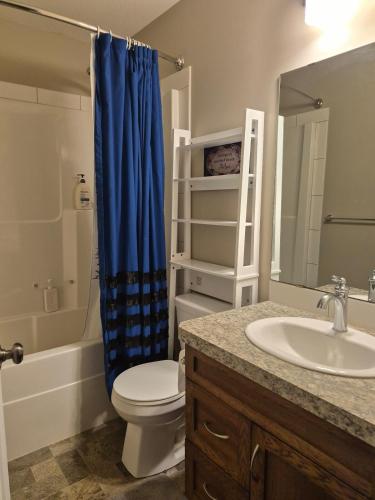 a bathroom with a toilet and a sink and a shower at Home Sweet Home in Red Deer