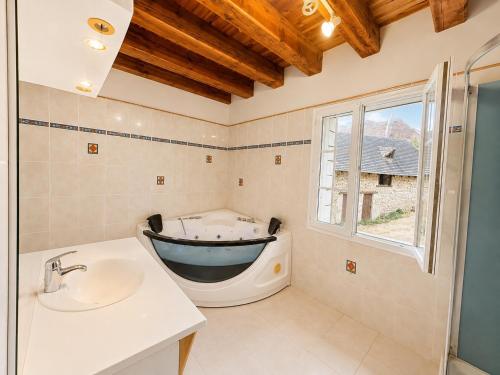 a bathroom with a tub and a sink and a window at La Maison de Renée in Sainte-Eulalie-dʼAns