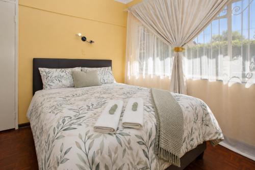 a bedroom with a bed with two towels on it at Spacious Holiday Home in Florida Park! Pool! Parking! Fast Wifi! in Roodepoort