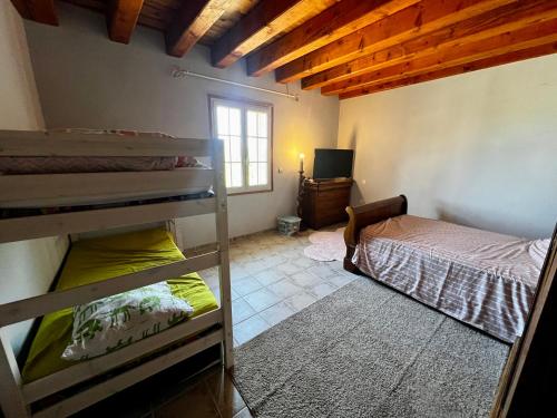 a room with two bunk beds and a television at La Maison de Renée in Sainte-Eulalie-dʼAns