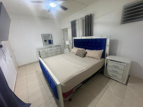 a bedroom with a bed with a blue headboard at Apto Próximo al Aeropuerto Gregorio Luperón in Puerto Plata