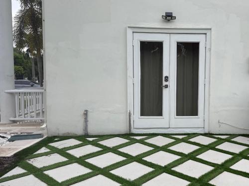 a white door on a white house with a tile floor at Homestay Weston Ranches in Southwest Ranches