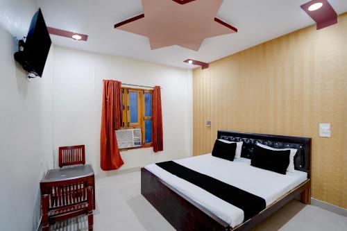 a bedroom with a bed and a television in it at Hotel O Jhandi Palace in Lakhīmpur