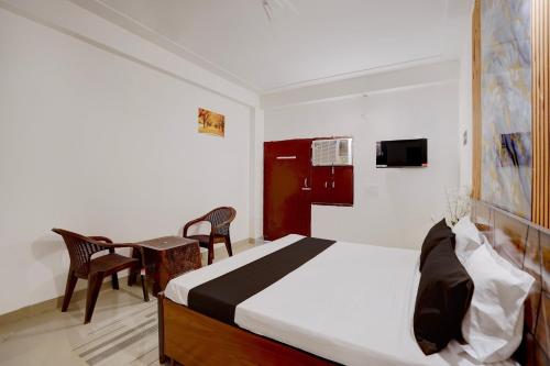 a bedroom with a bed and a table and chairs at Hotel O Moonlight Residency in Noida
