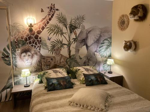 a bedroom with a bed with a mural of giraffes and animals at Villa piscine jacuzzi Mas la Bregeonière in Roquefort-les-Pins