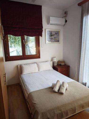 a bedroom with a bed with two towels on it at Red House Retreat Aegina Kontos in Kondós