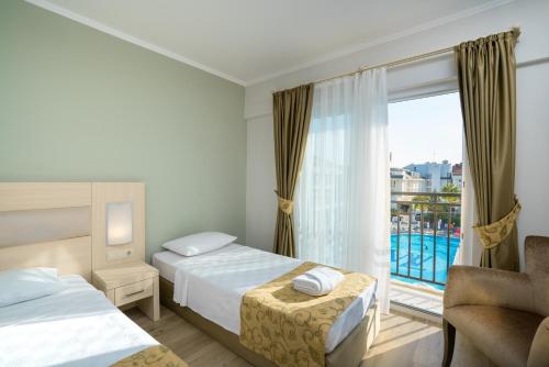 a hotel room with two beds and a window at White Lilyum Hotel - All Inclusive in Kemer