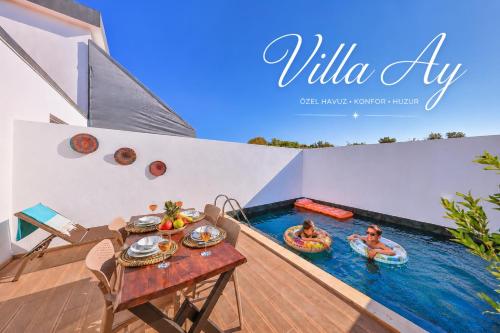 two people are in the water in a swimming pool at Villa Ay in Kaş