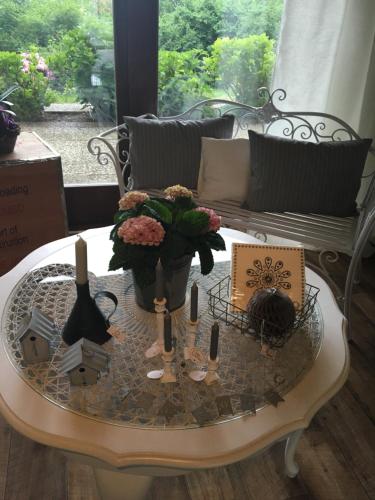 a coffee table with flowers and candles on it at Pension Panorama in Hitzacker