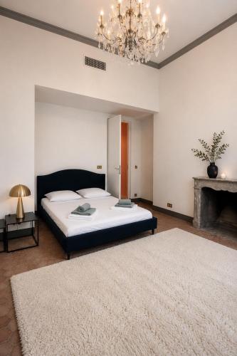 a bedroom with a large bed and a chandelier at L'écrin de la Chartreuse in Villeneuve-lès-Avignon