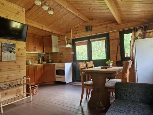 a kitchen with a table and a refrigerator at Osīšu Priežu māja in Ķesterciems