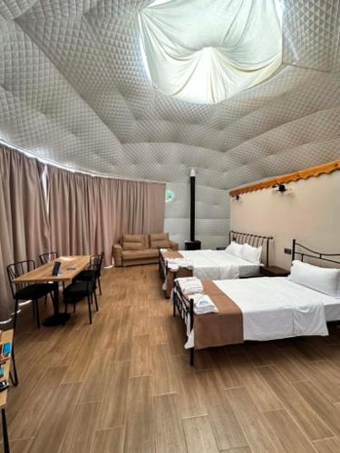 a room with three beds and a table and chairs at Shaori Space - შაორი სფეისი in Nikortsminda