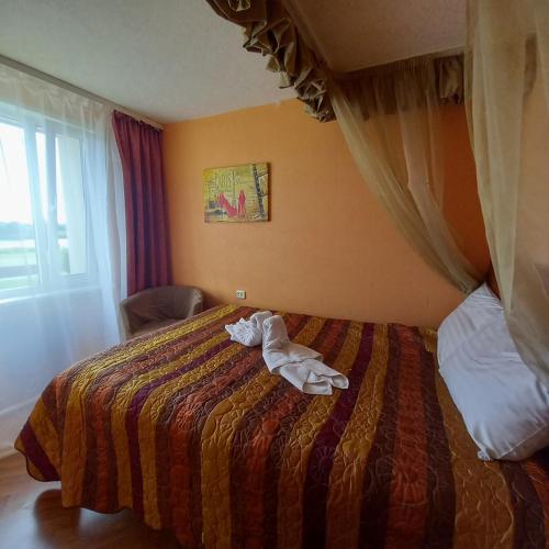 a hotel room with a bed with a towel on it at Campsite Jelgava in Jelgava