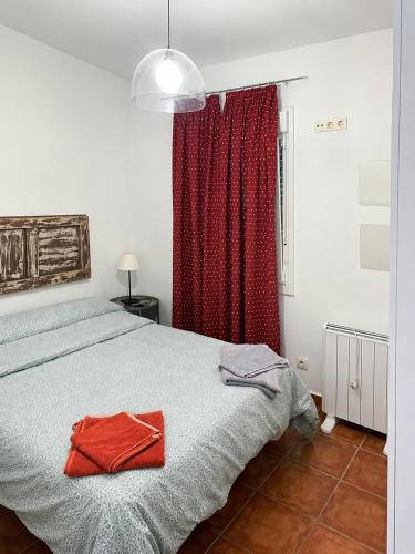 a bedroom with a bed with a red curtain at Apartamentos Las Fuentes in Labajos