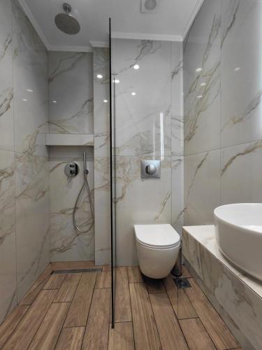 a bathroom with a toilet and a sink at POSEIDON SeaSide Deluxe Suites in Syvota