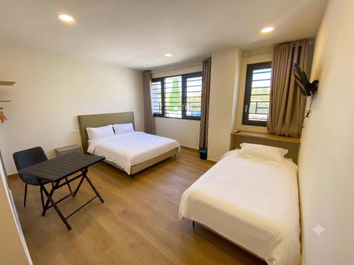a hotel room with two beds and a table at Hotel A&M Mostoles-Alcorcon-M506 in Alcorcón