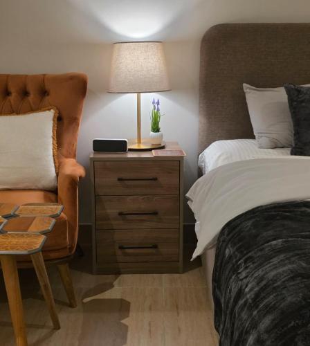 a bedroom with a bed and a lamp and a chair at Khobar Luxury Apartments in Al Khobar