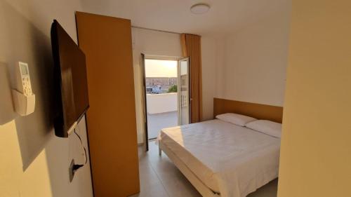 a bedroom with a bed and a door to a balcony at Il cedro blu in Santa Maria del Cedro