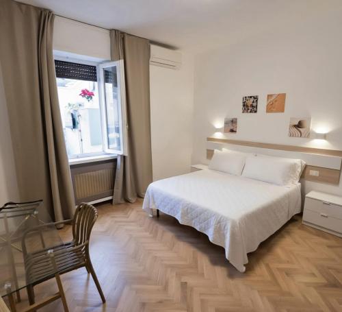 a bedroom with a bed and a chair and a window at Elycon House Bergamo - Locazione turistica a camere in Bergamo