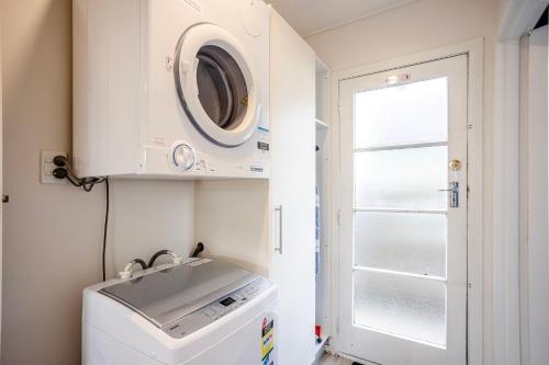 a laundry room with a washing machine and a window at Roslyn Sanctuary Hereford St Dunedin in Dunedin