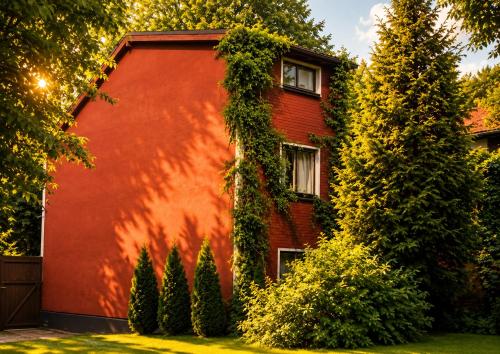 a red house with ivy on the side of it at Private house 2km from old town in Riga