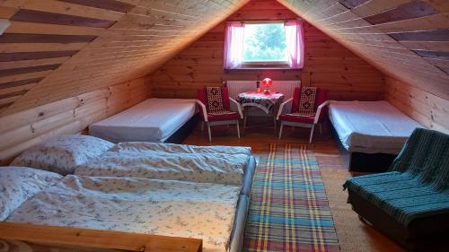 a attic room with a bed and a table and chairs at Chata Milka in Medzilaborce