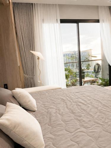 a bedroom with a large bed with a large window at The Opus One 1 in Long Bình