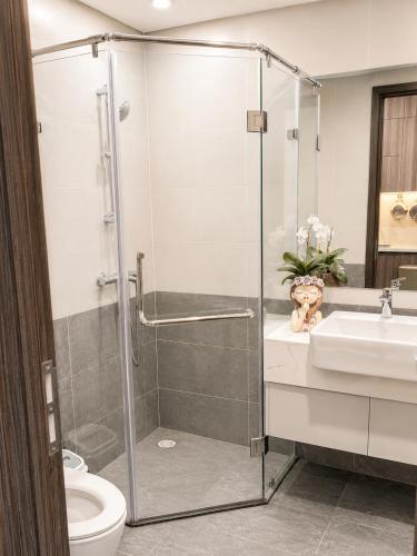 a bathroom with a shower and a toilet and a sink at The Opus One 1 in Long Bình