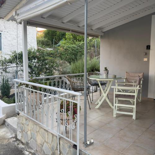 a patio with a table and chairs under a pergola at Saint Giovanni House in Kharokopión
