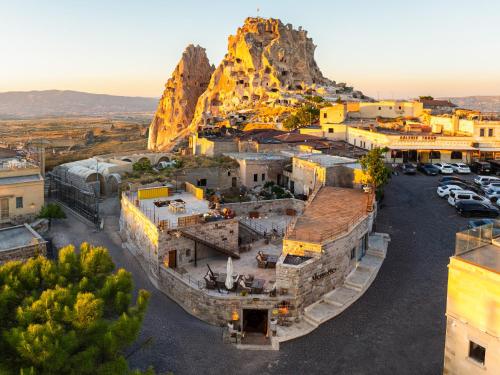 an old town with a mountain in the background at Memories Cave House in Uçhisar