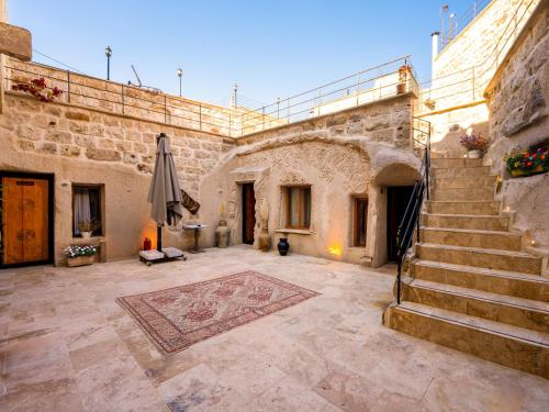 a stone building with a staircase and a patio at Memories Cave House in Uçhisar