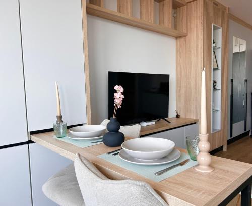 a dining room table with plates and a television at V'One - Cozy & Quiet Apartment - Free Parking in Timişoara